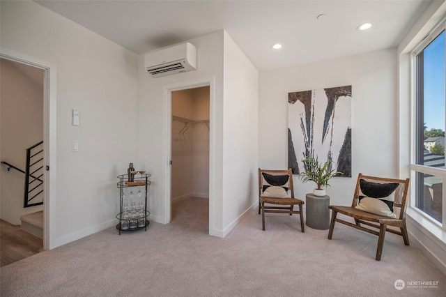 sitting room with an AC wall unit and light carpet