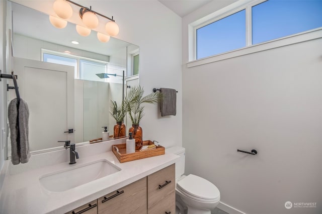 bathroom featuring vanity, toilet, and a shower with door