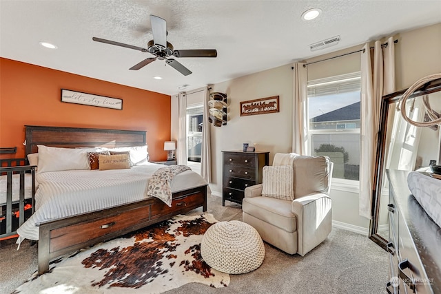 bedroom with light carpet, a textured ceiling, and ceiling fan