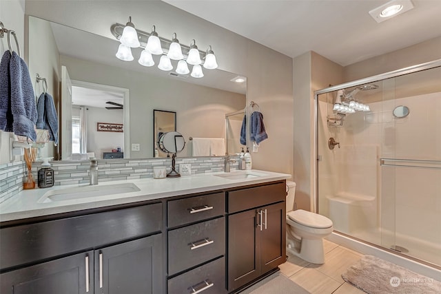 bathroom featuring vanity, tile patterned floors, decorative backsplash, toilet, and an enclosed shower