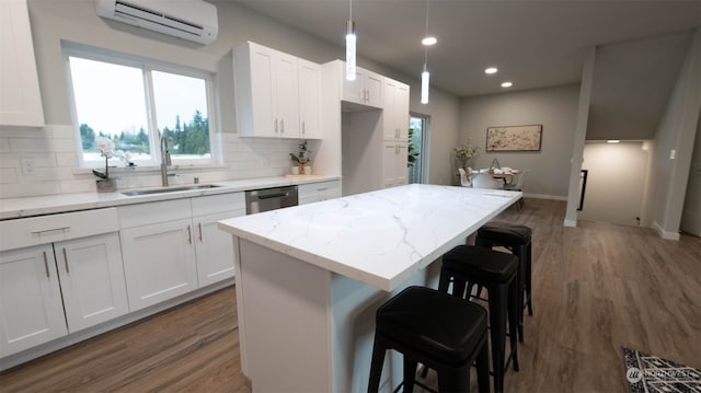 kitchen featuring white cabinetry, a kitchen bar, an AC wall unit, a kitchen island, and dark hardwood / wood-style flooring