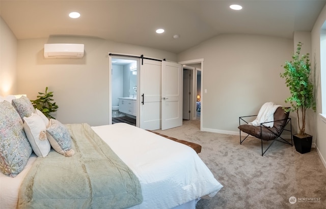 carpeted bedroom featuring a barn door, ensuite bathroom, a wall unit AC, and lofted ceiling