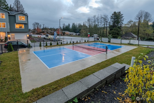 view of tennis court with a lawn