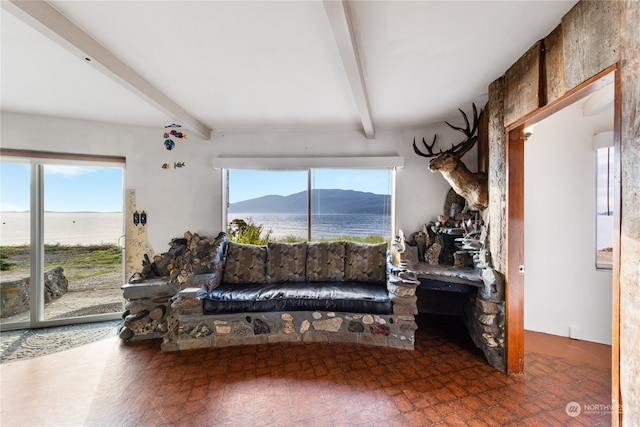 living room featuring a water and mountain view and beamed ceiling