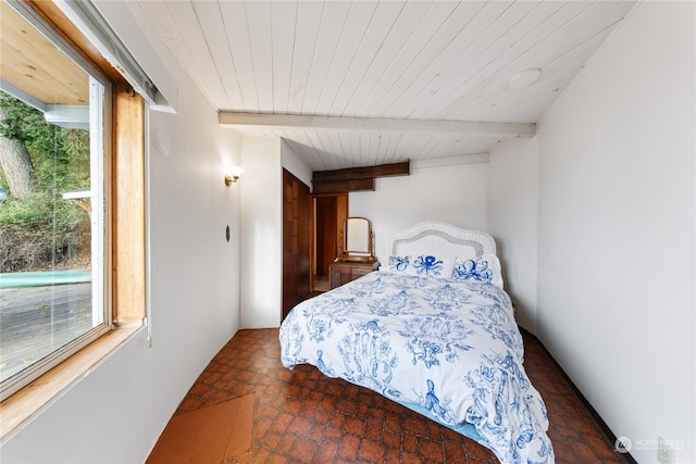 bedroom featuring beamed ceiling and multiple windows