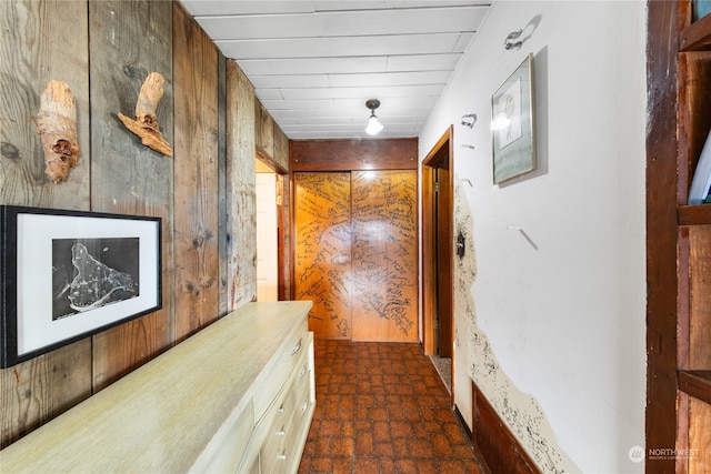 corridor featuring wood walls