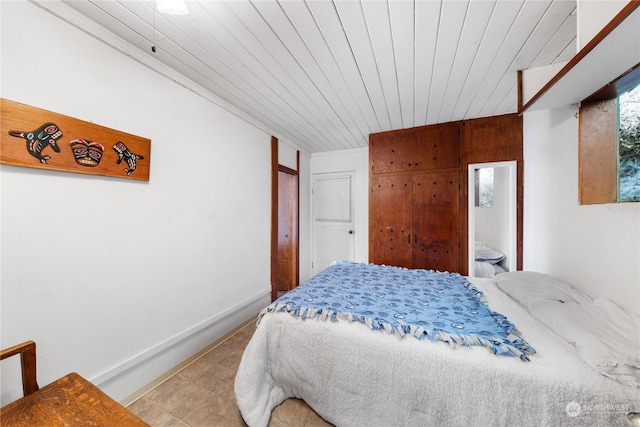 tiled bedroom featuring wooden ceiling, wood walls, and ensuite bath