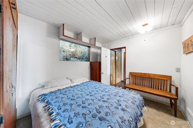 bedroom featuring a barn door, wooden ceiling, and light tile patterned flooring