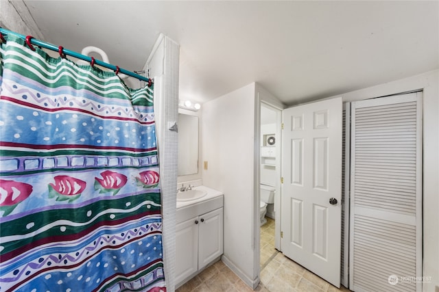 bathroom with curtained shower, vanity, and toilet