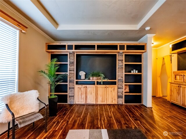 living room featuring ornamental molding, dark hardwood / wood-style flooring, and a tray ceiling