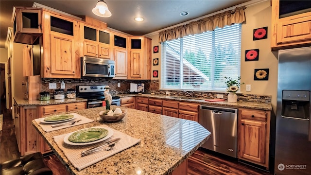 kitchen featuring light stone countertops, appliances with stainless steel finishes, and a center island