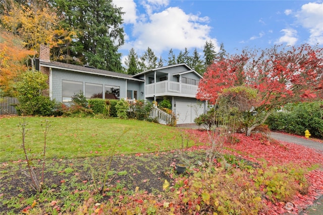 view of front of property with a balcony, a front lawn, and a garage