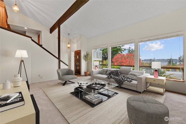 carpeted living room with lofted ceiling with beams