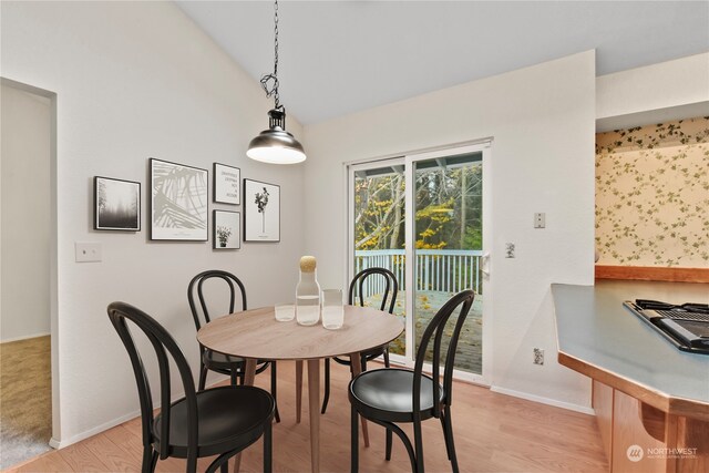 dining area featuring vaulted ceiling and light wood-type flooring