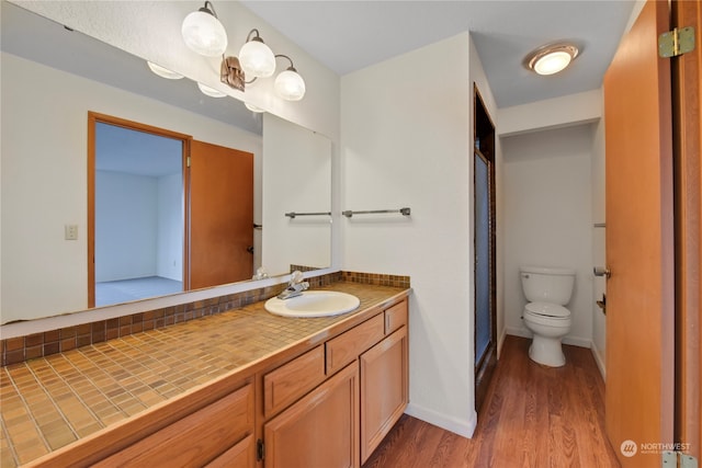 bathroom with vanity, hardwood / wood-style flooring, and toilet