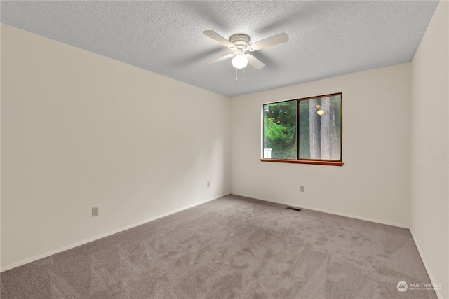 carpeted empty room with ceiling fan and a textured ceiling