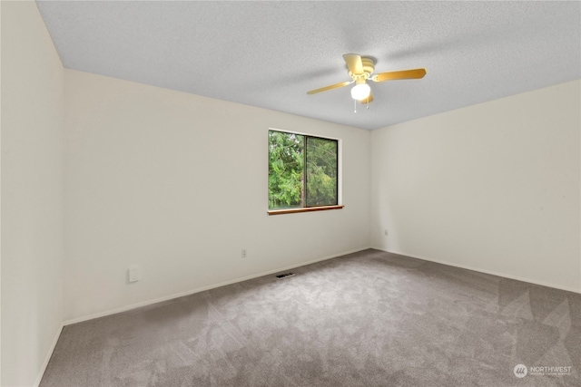 carpeted empty room featuring a textured ceiling and ceiling fan