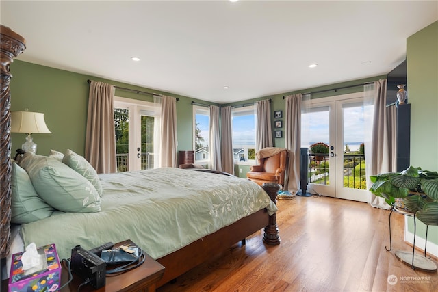 bedroom with access to outside, wood finished floors, and french doors