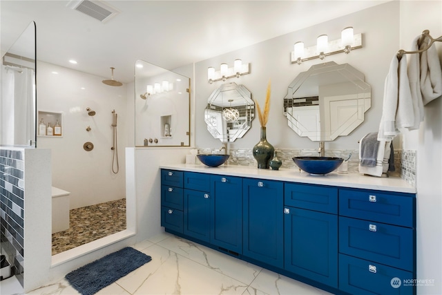 full bath with marble finish floor, visible vents, walk in shower, and a sink