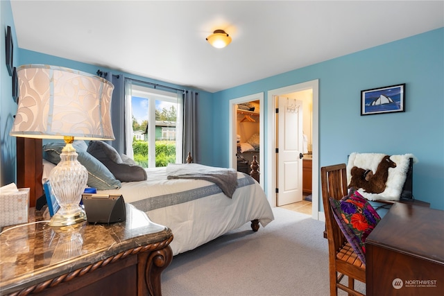 bedroom featuring light carpet, a spacious closet, and a closet