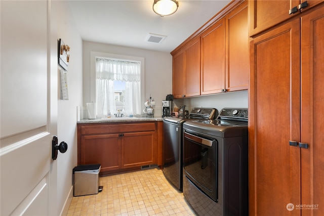 washroom with cabinet space, visible vents, a sink, independent washer and dryer, and baseboards