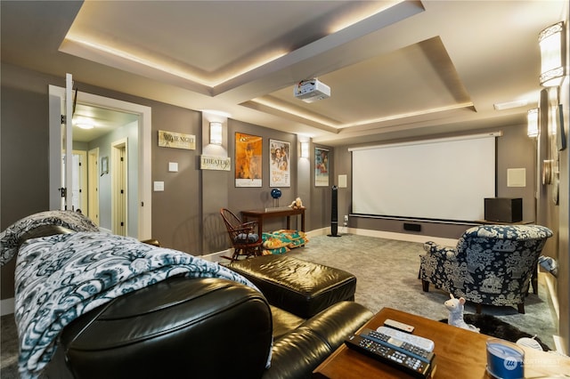 cinema featuring carpet floors, a raised ceiling, and baseboards