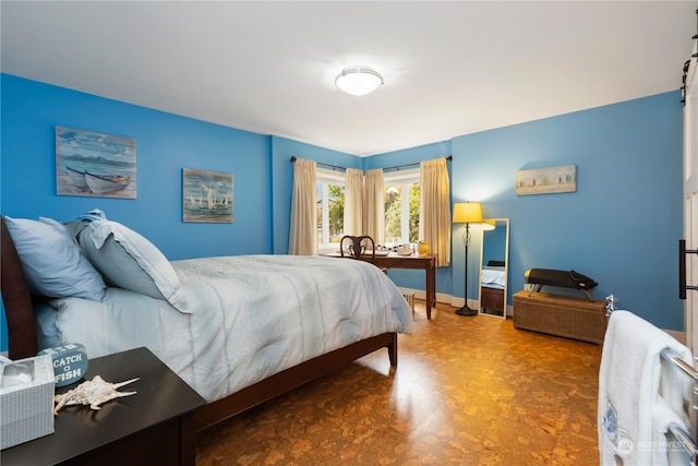 bedroom featuring dark floors and baseboards