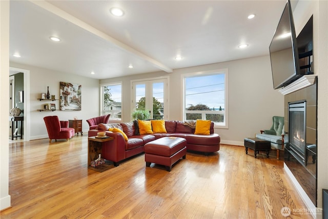 living area featuring french doors, light wood finished floors, recessed lighting, a tile fireplace, and baseboards