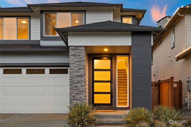 exterior entry at dusk with a garage