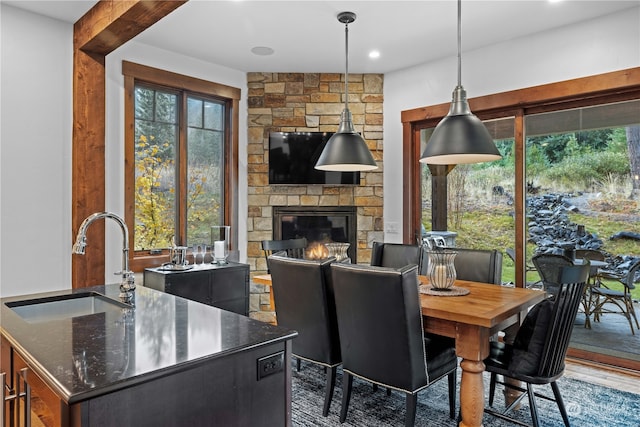 dining room with a fireplace, sink, and dark wood-type flooring