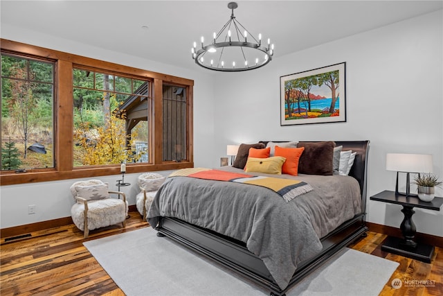 bedroom featuring wood-type flooring and an inviting chandelier