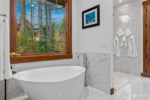 bathroom with a bathtub and tile walls