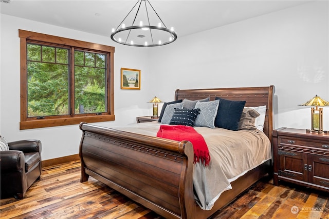 bedroom featuring a notable chandelier and wood-type flooring