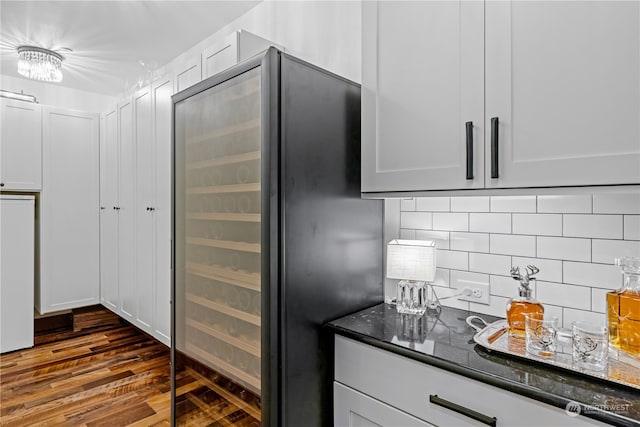 kitchen featuring white cabinets, decorative backsplash, dark hardwood / wood-style flooring, and built in refrigerator