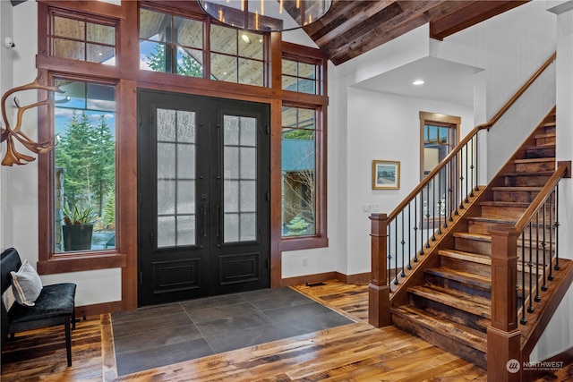 entrance foyer with beamed ceiling, french doors, dark hardwood / wood-style flooring, and a healthy amount of sunlight