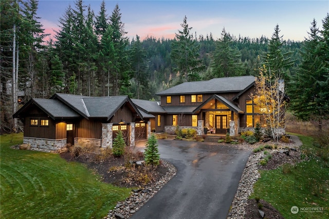 craftsman inspired home with a garage and a lawn