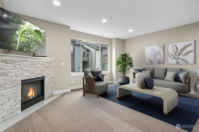 living room featuring light carpet and a stone fireplace