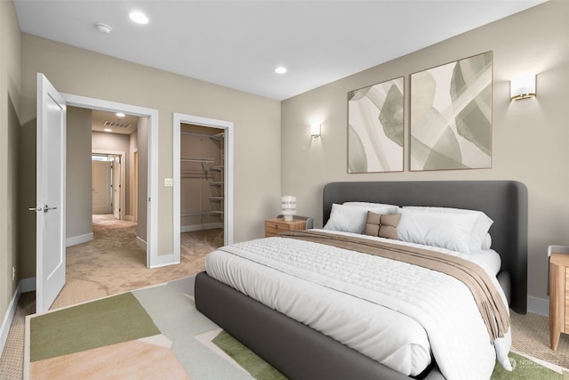 carpeted bedroom featuring a walk in closet and a closet