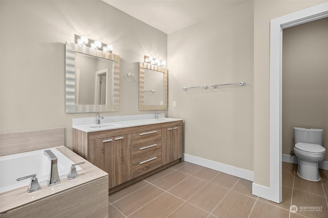 bathroom featuring tile patterned floors, a washtub, vanity, and toilet