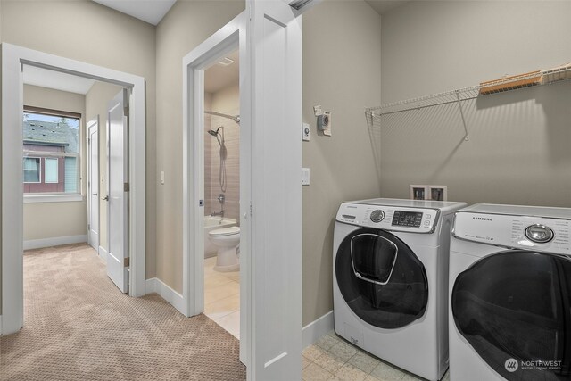 laundry room with washing machine and dryer and light colored carpet