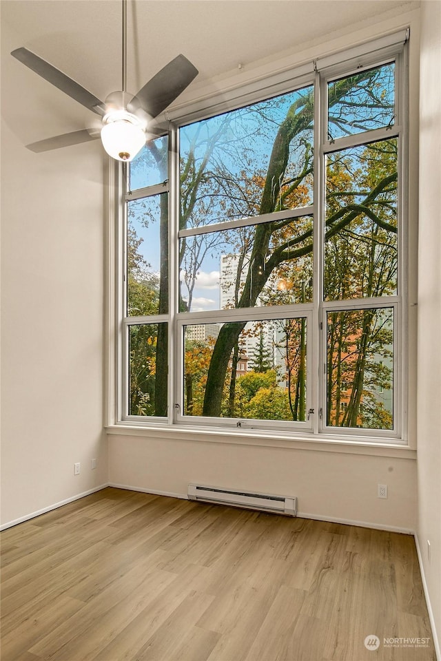 1000 Union St Unit 205, Seattle, WA 98101 - empty room featuring a baseboard radiator, wood finished floors, and a ceiling fan