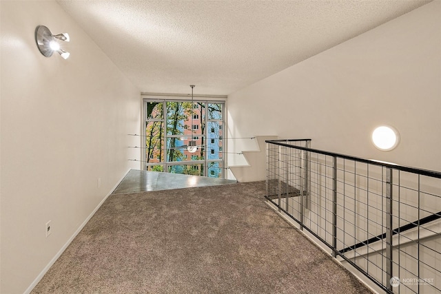 1000 Union St Unit 205, Seattle, WA 98101 - hallway featuring a textured ceiling, carpet flooring, and an upstairs landing