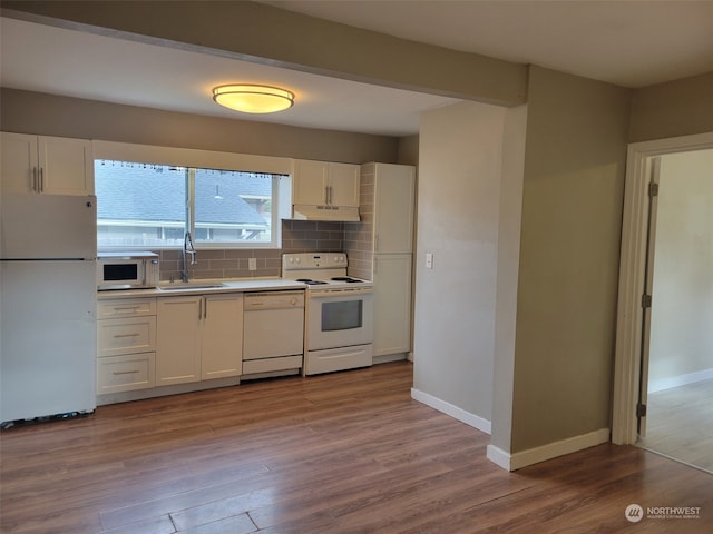 kitchen with tasteful backsplash, sink, white appliances, and light wood-type flooring