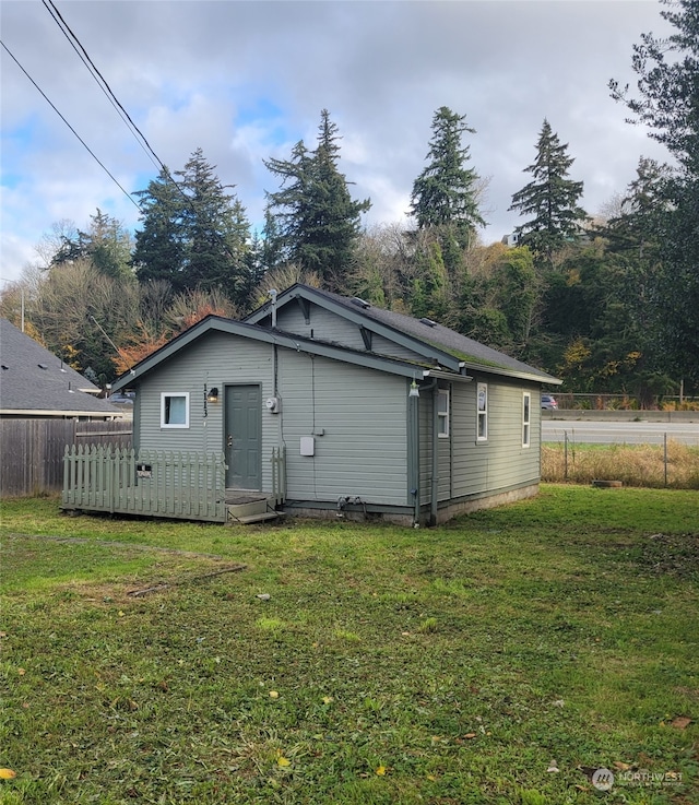 back of property featuring a lawn and a wooden deck