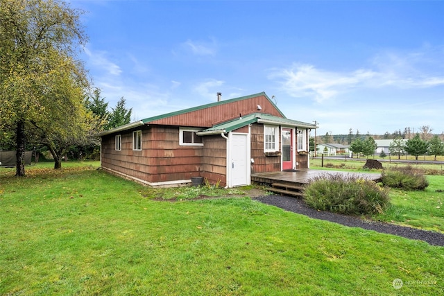 rear view of house with a lawn and a wooden deck