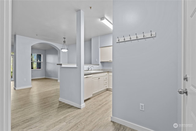 kitchen with pendant lighting, light hardwood / wood-style floors, white cabinetry, and white dishwasher