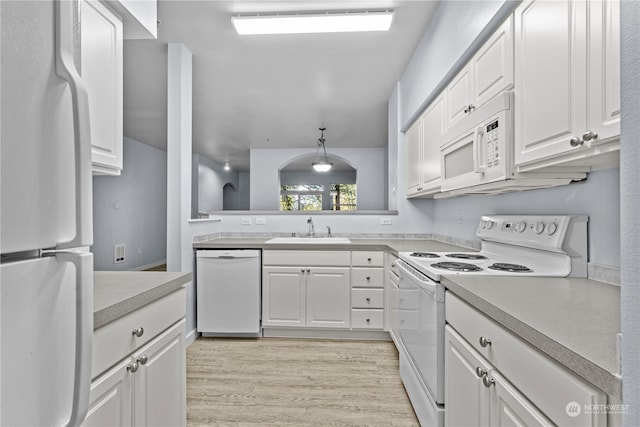 kitchen featuring hanging light fixtures, white appliances, white cabinets, and sink