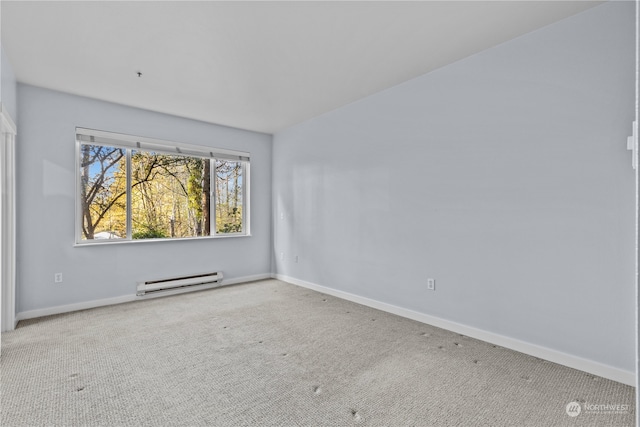 carpeted spare room with a baseboard heating unit