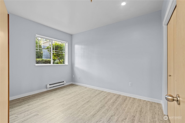 unfurnished bedroom featuring light hardwood / wood-style flooring, a closet, and a baseboard heating unit