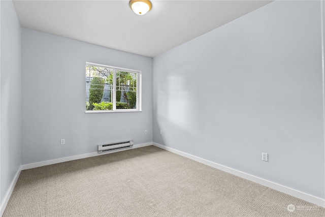 empty room featuring carpet and a baseboard heating unit